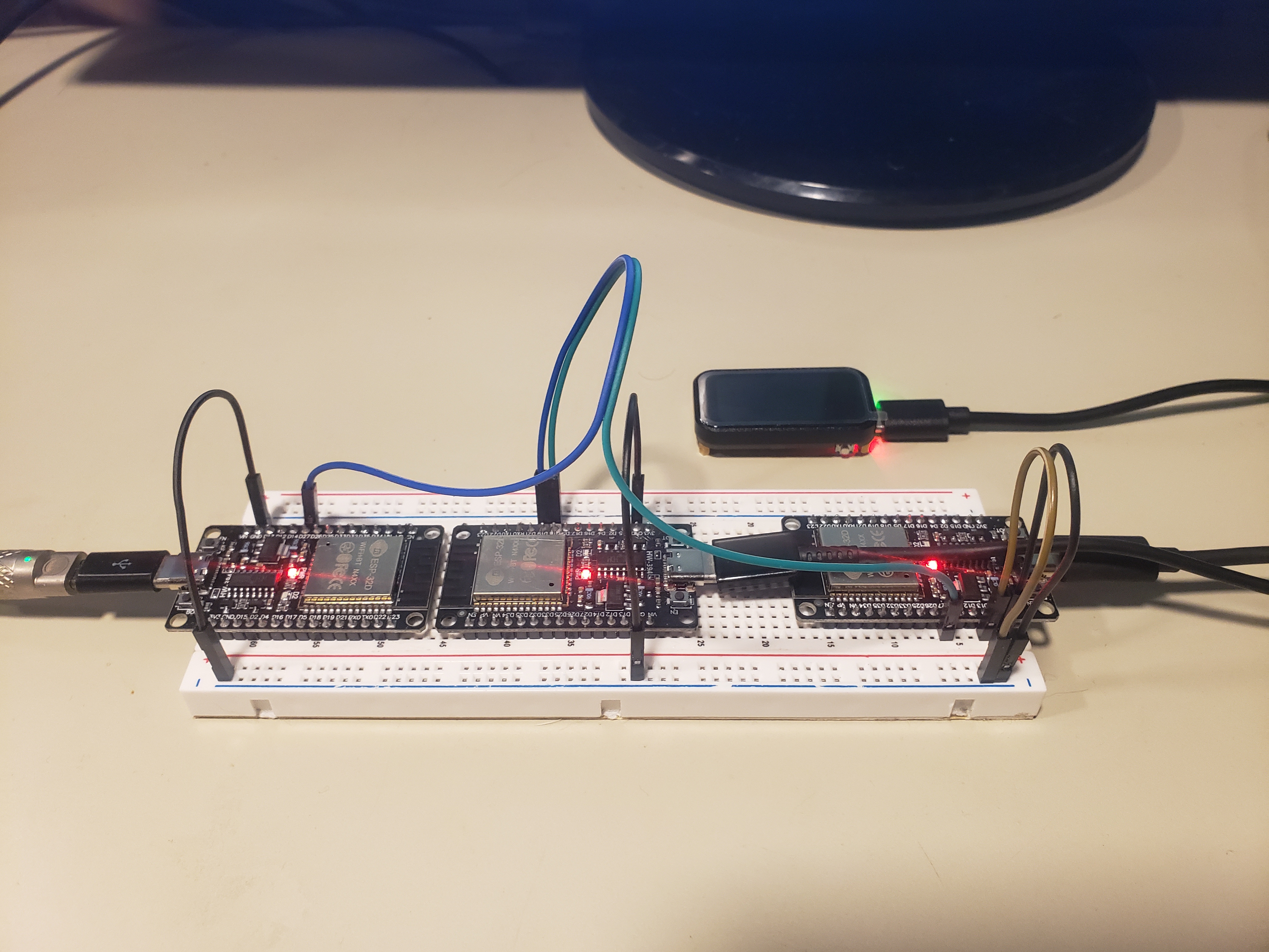 Three ESP32 boards on a shared breadboard — two LOLIN32 sensor simulators on the left, the ESP32-C6 head unit with display on the right